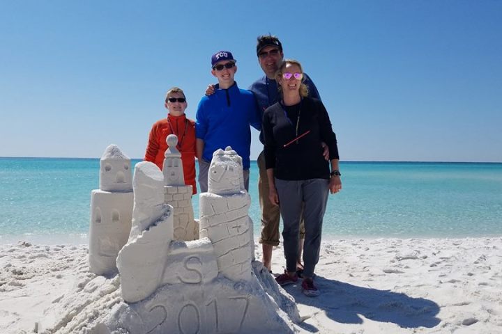 family of four creating sand sculptures